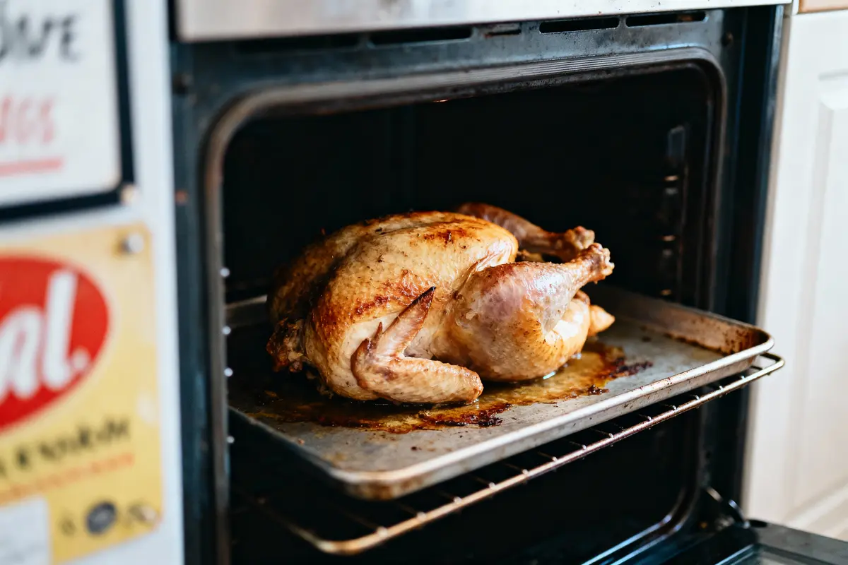 Poulet rôti dans un four, posé sur une plaque de cuisson en métal.