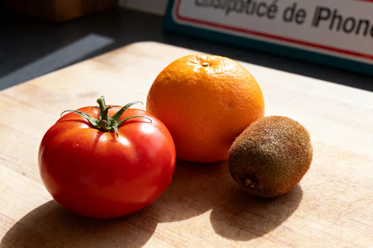 pexels-michal-pech-213601-757318 (1) Tomate, orange et kiwi sur planche en bois, éclairés par la lumière du jour.