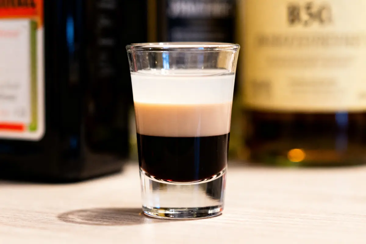 Verre de B52 drink shot à trois couches sur une table éclairée